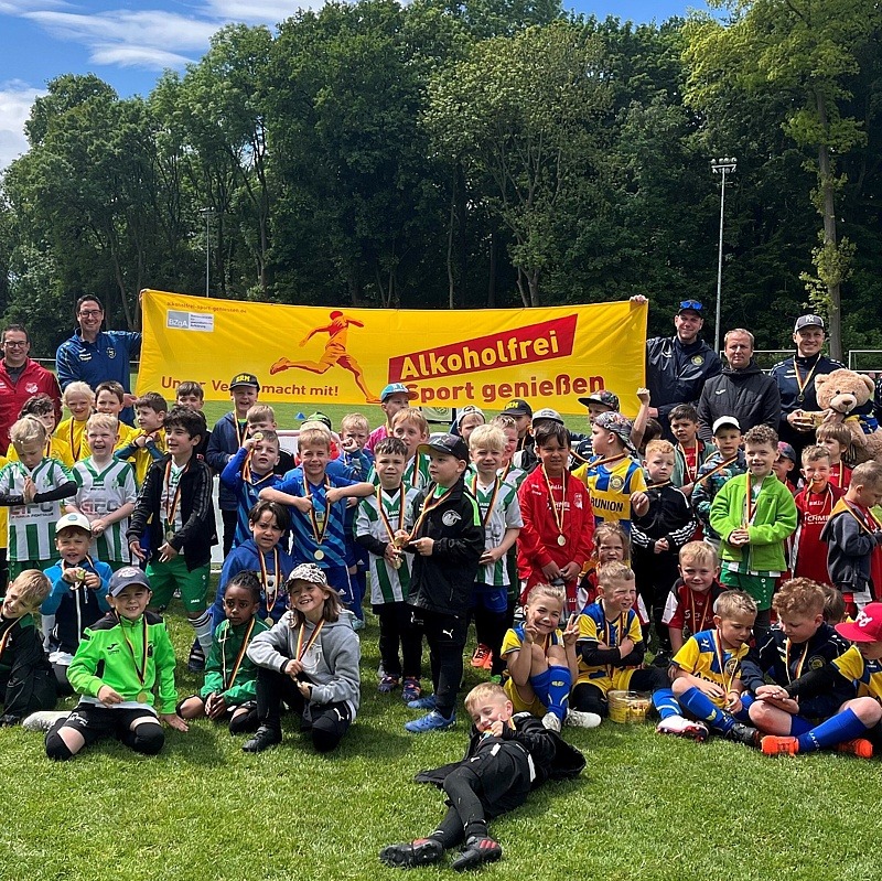 Alle Teilnehmende des Gewinnervereins FSV Raßnitz auf dem Fußballfeld vor dem „Alkoholfrei Sport genießen“-Banner