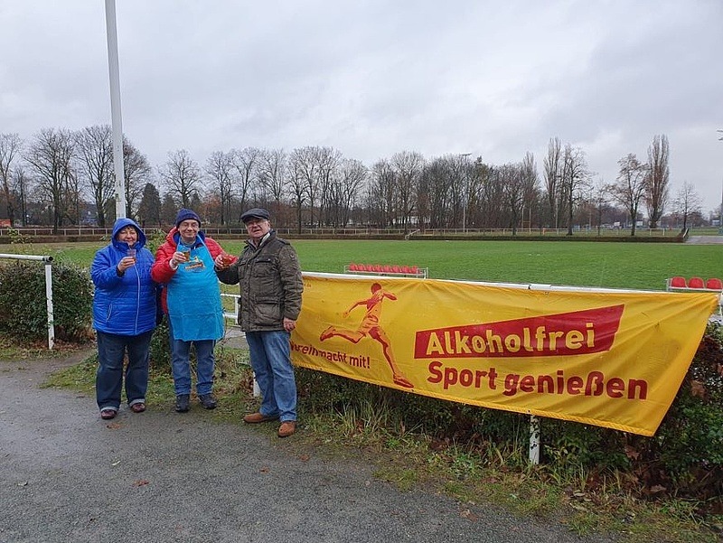 Drei Teilnehmer der Boule-Winterserie vor dem "Alkholhofrei Sport geniessen"-Banner.