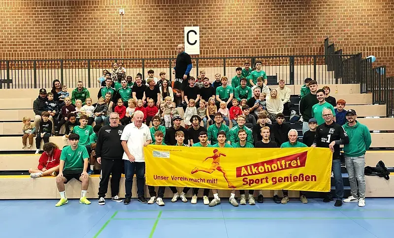 Teilnehmende und Gäste des Fußballturniers beim FC Weiden-Ost vor dem „Alkoholfrei Sport genießen“-Aktionsbanner