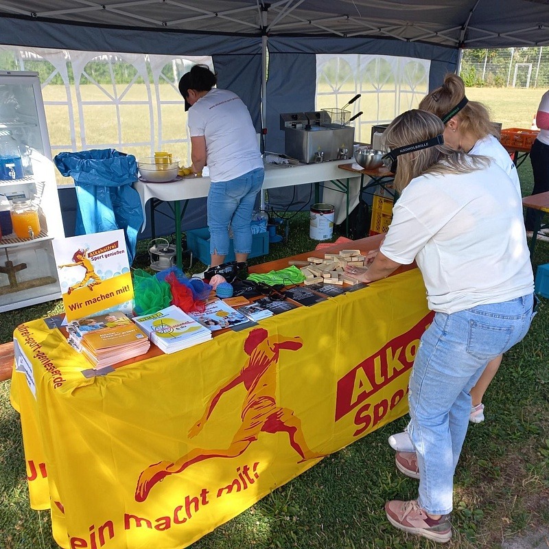 Der Infotand mit „Alkoholfrei Sport genießen“-Aktionsbanner, an dem sich Jugendliche mit Rauschbrille beim Holzklötze-Stapel-Spiel übten.