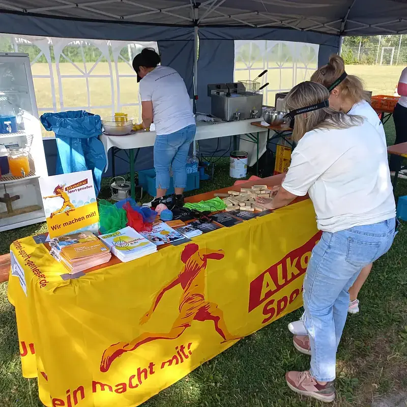 Der Infotand mit „Alkoholfrei Sport genießen“-Aktionsbanner, an dem sich Jugendliche mit Rauschbrille beim Holzklötze-Stapel-Spiel übten.