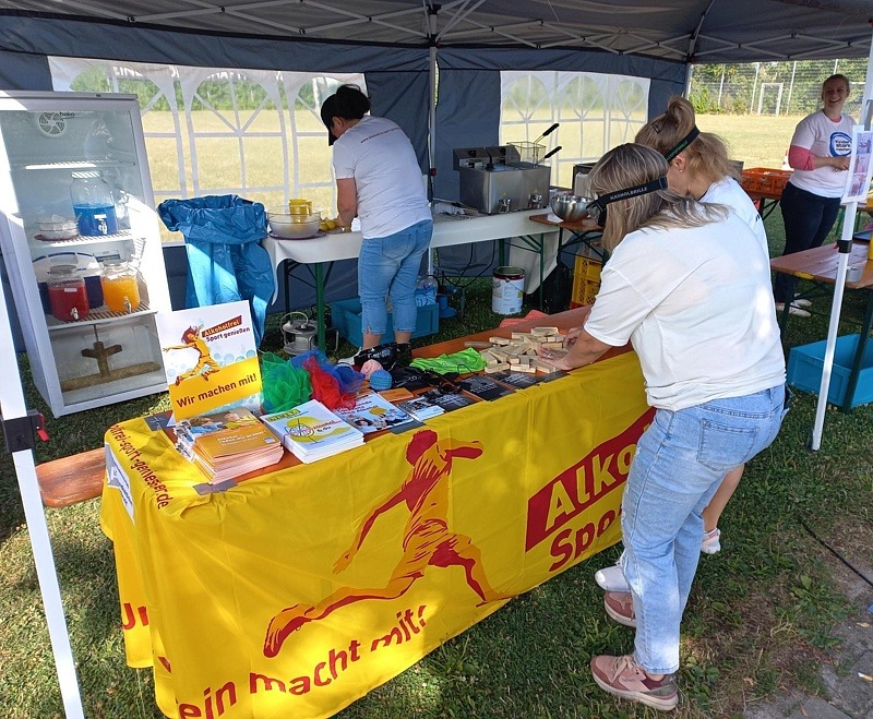 Der Infotand mit „Alkoholfrei Sport genießen“-Aktionsbanner, an dem sich Jugendliche mit Rauschbrille beim Holzklötze-Stapel-Spiel übten.