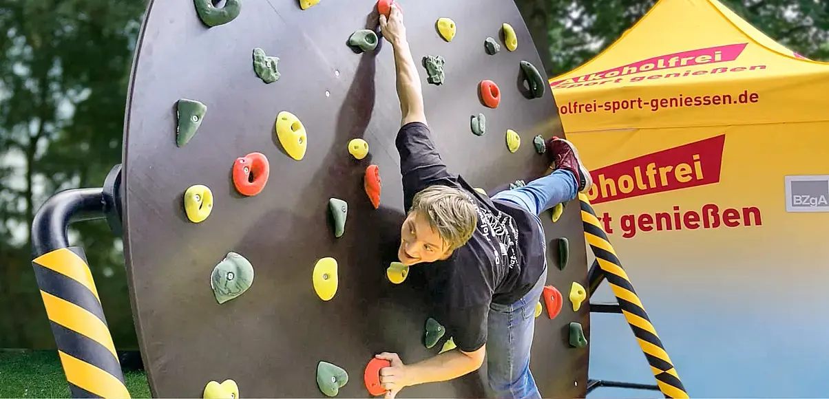 Ein Mann hängt an einer Kletterwand.