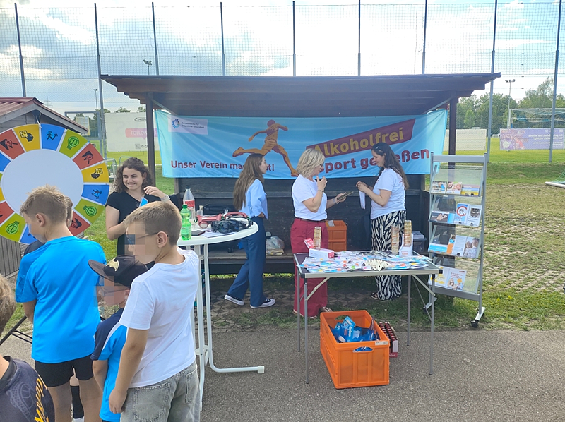 Blick auf den Infostand mit dem blau-orangenem Aktionsbanner von "Alkoholfrei Sport genießen" am Aktionstag des TSV Königsbrunn.
