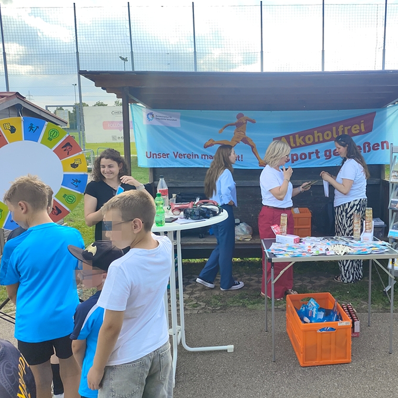 Blick auf den Infostand mit dem blau-orangenem Aktionsbanner von "Alkoholfrei Sport genießen" am Aktionstag des TSV Königsbrunn.