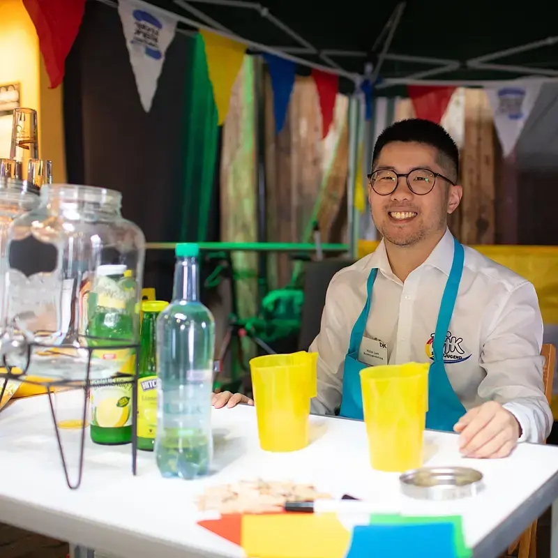 Ein DJK-Jugendlicher hinter der Theke des Cocktailstands für alkoholfreie Cocktails.