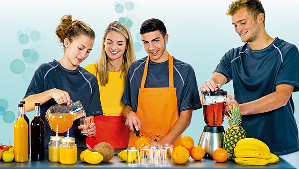 Nia Künzer mit Jugendlichen beim Mixen frischer Saftcocktails