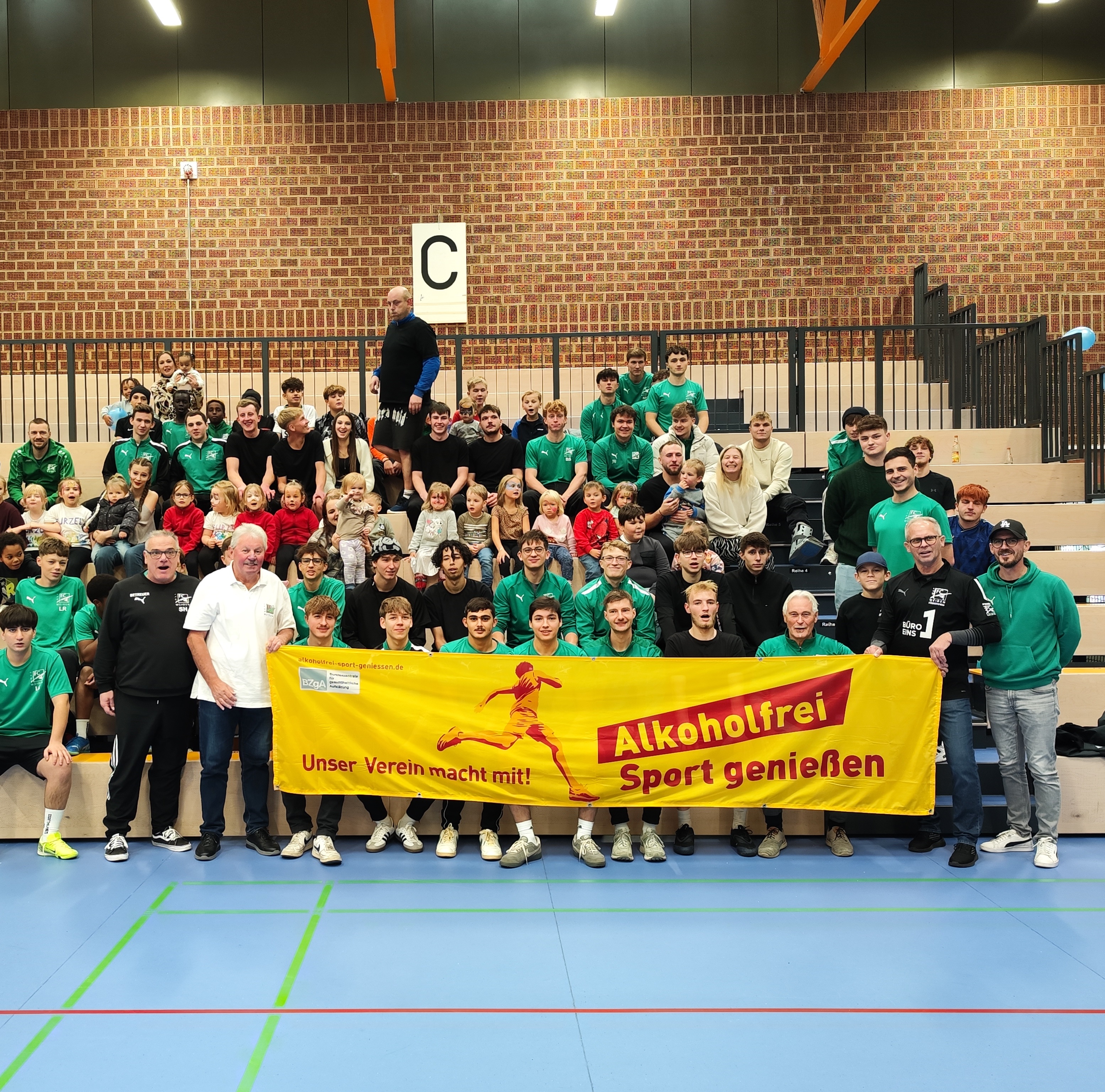  Teilnehmende und Gäste des Fußballturniers beim FC Weiden-Ost vor dem „Alkoholfrei Sport genießen“-Aktionsbanner